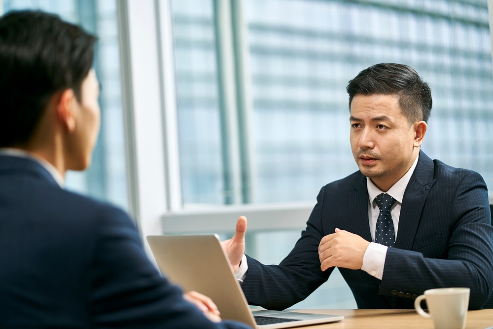 Business professionals in suits having an interview meeting in an office, symbolizing executive search and recruitment.