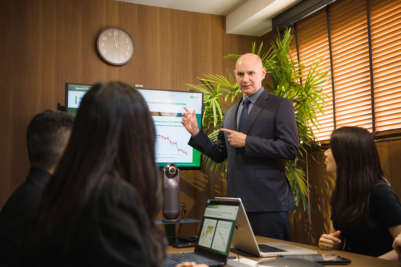 Business scene where a man and a woman in suits are discussing while looking at a computer.