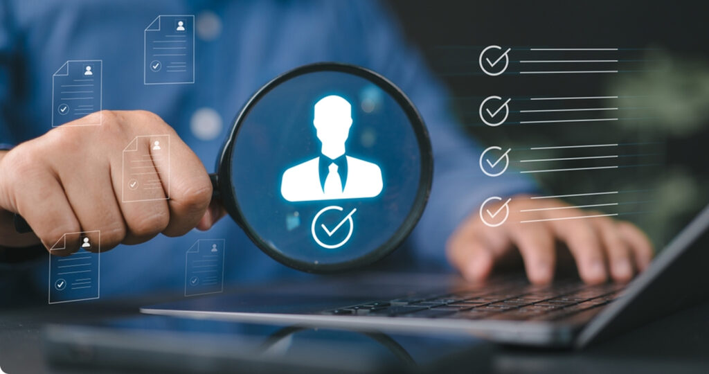 Person using a laptop with magnifying glass highlighting candidate icon, symbolizing executive search and recruitment.