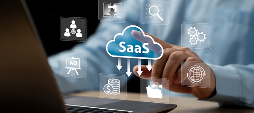 Businessman using laptop with SaaS cloud service icons representing software, data storage, and digital technology.
