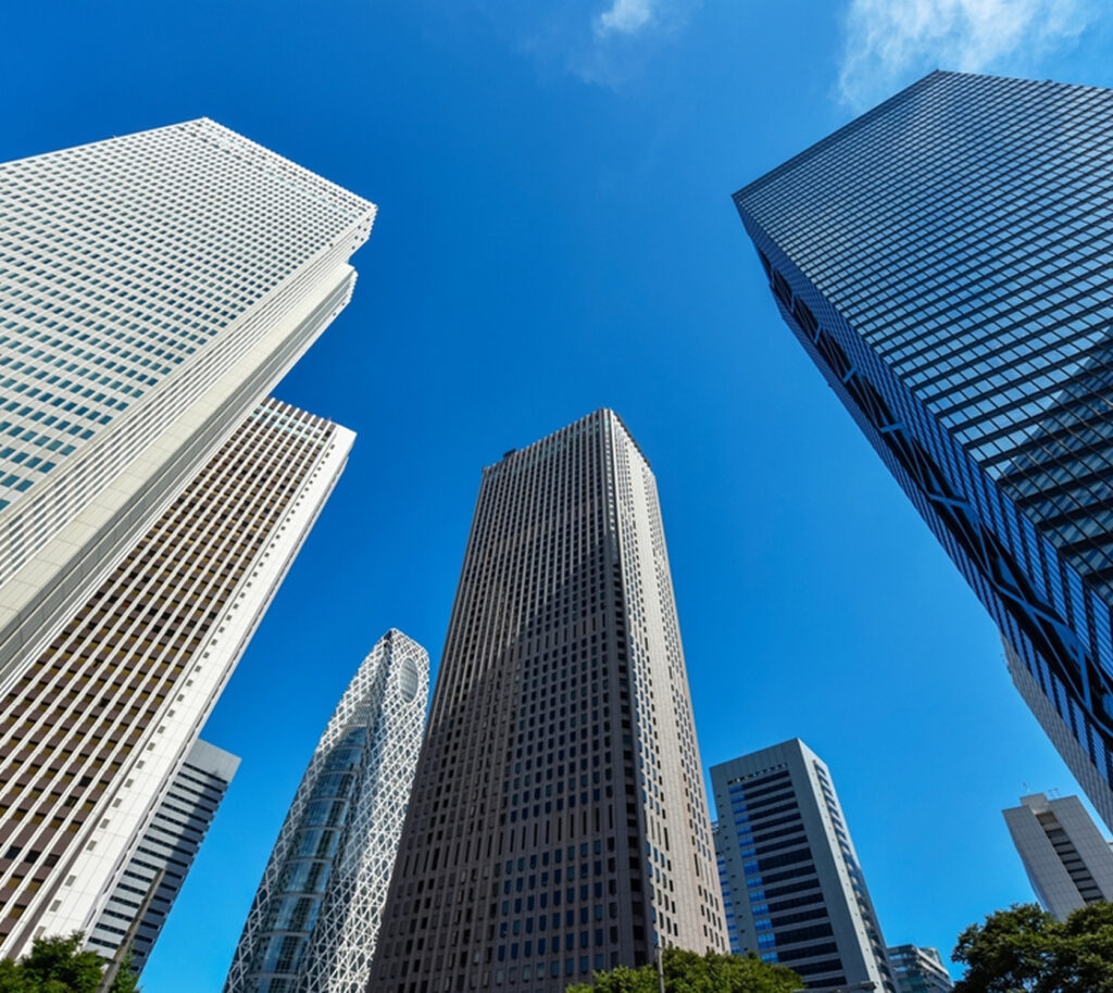 Photo of a group of skyscrapers viewed from below, with a clear blue sky above.